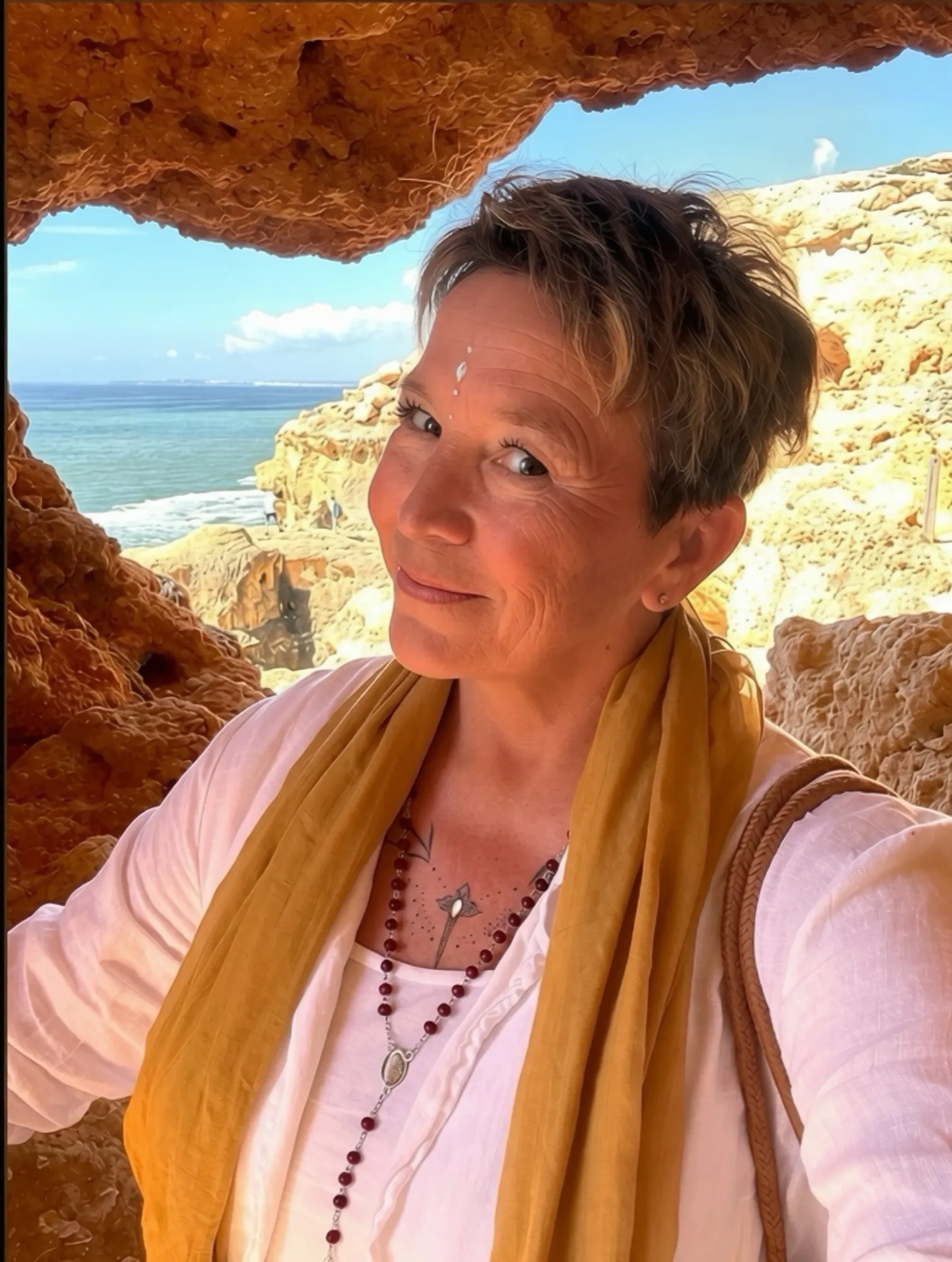 Nathalie Sauvé, souriante, dans une grotte ouverte sur la mer